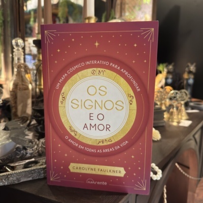 Capa de livro vermelha com o título Os Signos e o Amor e detalhes dourados