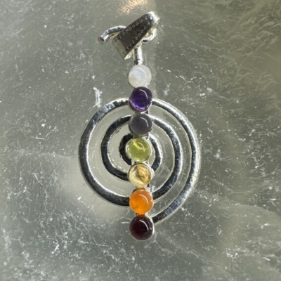 Pendente de metal prateado com três círculos e sete pedras coloridas alinhadas verticalmente
