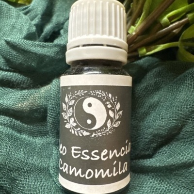 Frasco de óleo essencial de camomila com rótulo cinza e texto em branco.