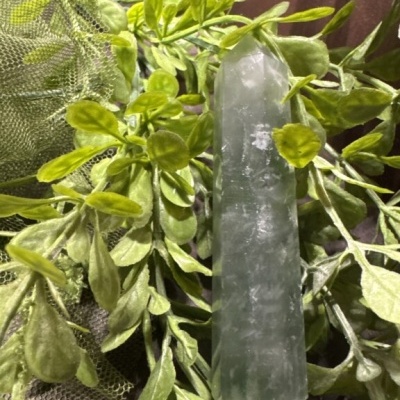 Pedra verde polida sobre folhas verdes artificiais