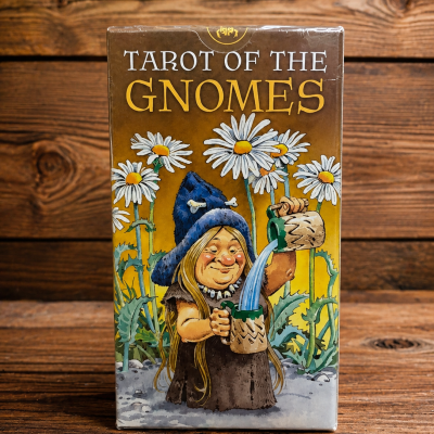 Caixa de Tarot of the Gnomes com ilustração de gnomo e flores sobre mesa de madeira