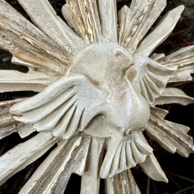 Escultura decorativa de pássaro branco com detalhes dourados e asas abertas