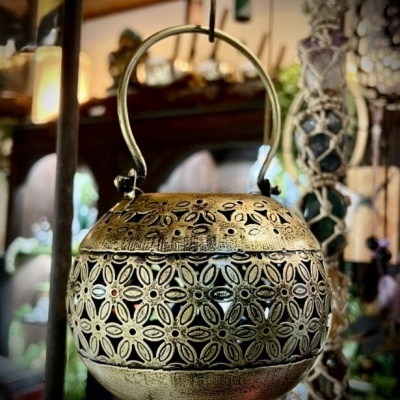 Lanterna decorativa dourada em metal com padrão floral recortado suspensa