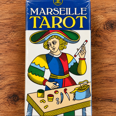 Caixa de baralho Marseille Tarot com ilustração colorida de personagem e texto