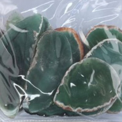 Pedras verdes com bordas brancas em saco plástico transparente