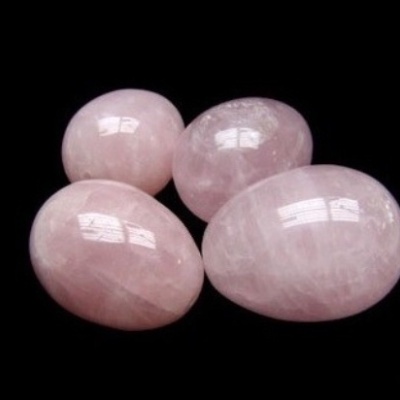 Pedras polidas de quartzo rosa em fundo preto