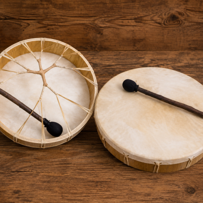 Dois tambores tradicionais com baquetas sobre mesa de madeira rústica