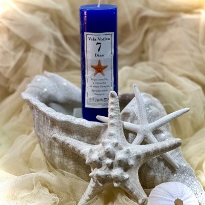 Vela votiva azul com estrela do mar em concha branca e elementos marinhos brancos