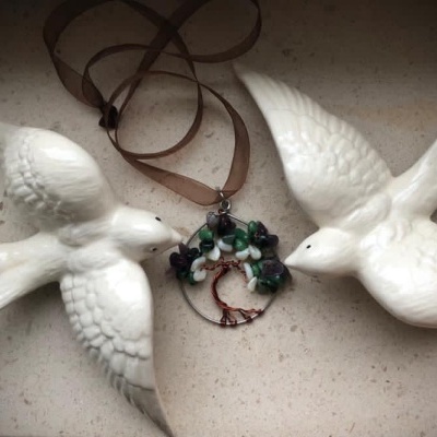 Ornamentos de pássaros brancos em cerâmica e pendente com árvore da vida em arame e pedras colado