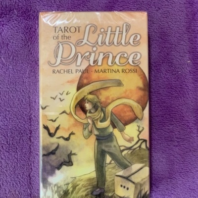 Caixa do tarot The Little Prince com ilustração de rapaz e planeta