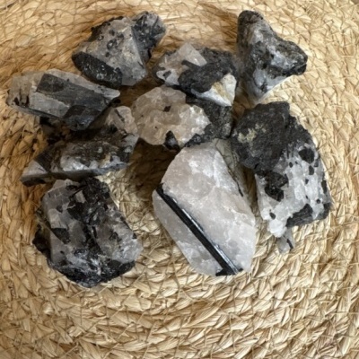 Pedras minerais brancas e pretas sobre tapete trançado