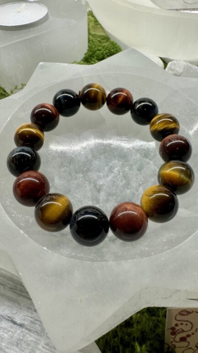 Pulseira de bolas coloridas em base branca translúcida com fundo verde