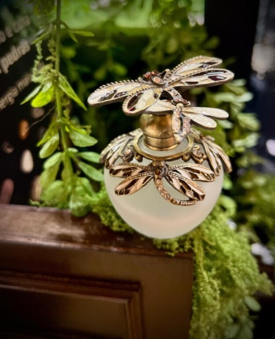 Frasco de perfume opaco com tampa decorada com libélulas douradas e pedras transparentes