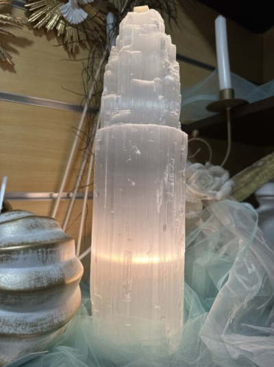 Escultura de cristal transparente com luz interior sobre tecido azul claro