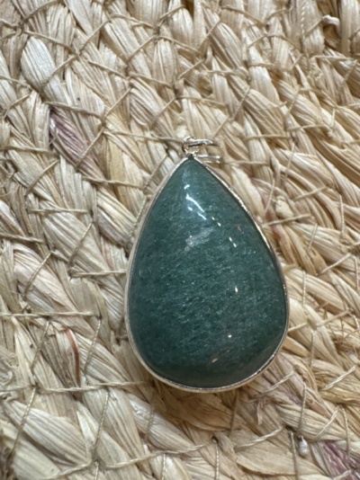Pendente gota verde com metal prateado sobre tecido trançado