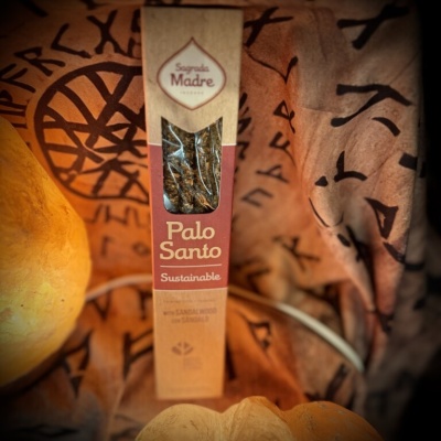 Caixa de incenso Palo Santo Sagrada Madre sobre tecido castanho com símbolos.