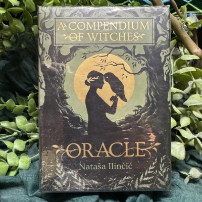 Caixa de cartas Oracle A Compendium of Witches com figura feminina e corvo em design dourado e cinza