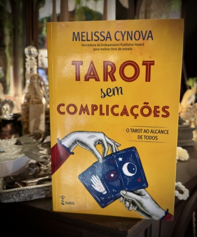 Capa amarela de livro Tarot sem Complicações com ilustração de mãos e cartas de tarot