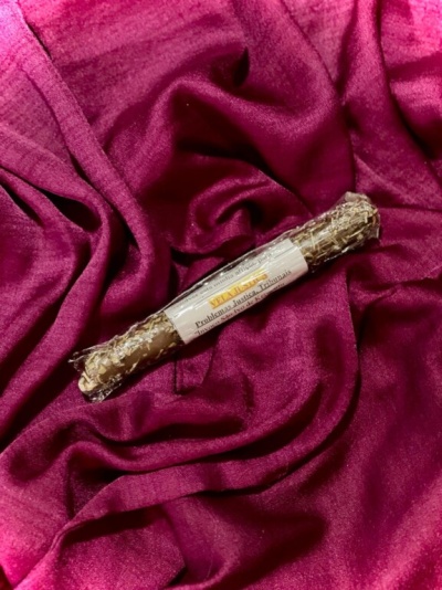 Vela de ervas seca com etiqueta sobre tecido de veludo rosa escuro