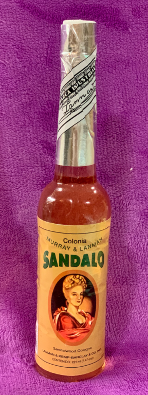 Garrafa de colónia de sândalo com rótulo amarelo e imagem de mulher antiga