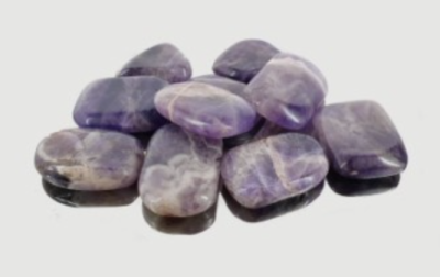 Pedras lisas polidas em tons roxo e branco sobre fundo branco