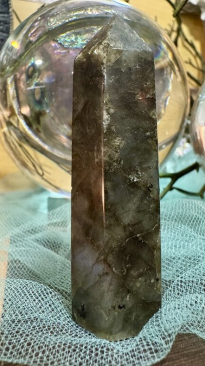 Cristal de quartzo fumado em forma de obelisco sobre tecido azul claro