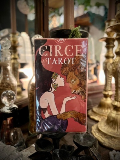 Caixa vermelha com cartas de tarot Circe Tarot e ilustração de mulher e leão