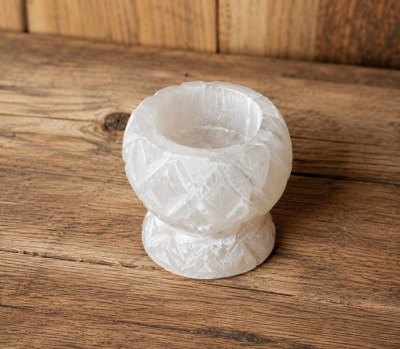 Vaso pequeno decorativo em cristal branco sobre mesa de madeira