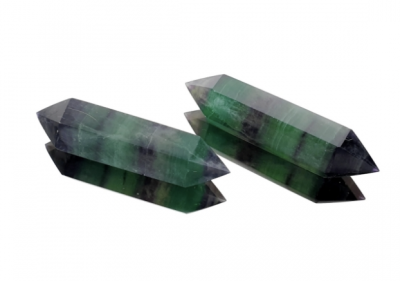 Duas pedras de cristal verdes e roxas em forma de varinha, sobre fundo branco