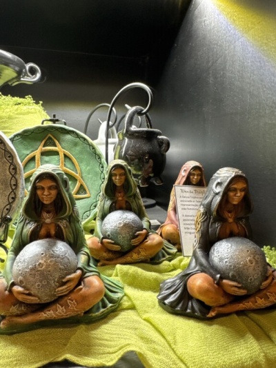 Figuras femininas segurando esferas tipo Lua em tecido verde