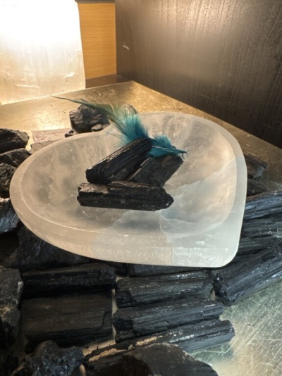 Prato transparente em forma de coração com carvão e pena azul