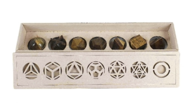Conjunto de sete pedras polidas castanhas em caixa de madeira com recortes geométricos