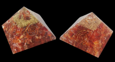 Duas pirâmides decorativas de resina com pedras vermelhas e douradas e espirais metálicas.