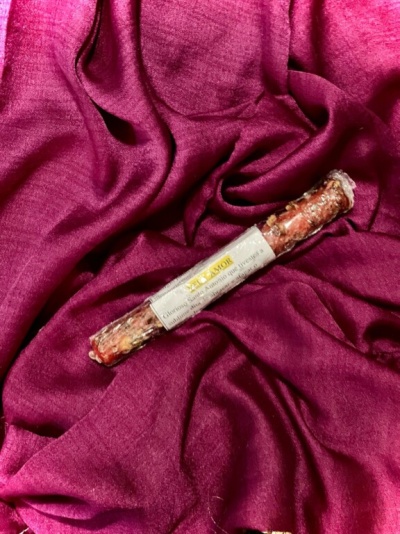 Chouriço seco tradicional com etiqueta sobre tecido vermelho vinho