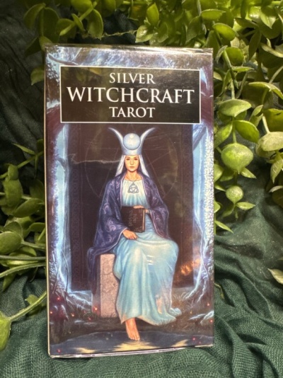 Caixa de baralho de tarot com figura feminina vestida de azul sentada, título SILVER WITCHCRAFT TAROT