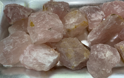 Pedras brutas de quartzo rosa numa bandeja metálica prateada