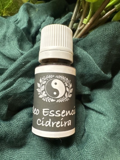 Frasco de óleo essencial cidreira sobre tecido verde