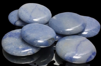 Pedras redondas polidas azul claro com veios em superfície preta