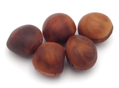 Cinco castanhas com casca castanha lisa e tonalidades escuras sobre fundo branco.