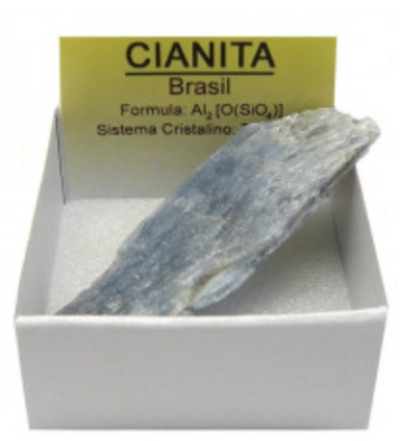 Mineral Cianita azul acinzentada numa caixa branca com cartão amarelo explicativo