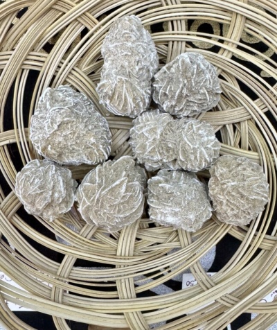 Cristais de selenite em forma de folhas numa cesta de vime circular