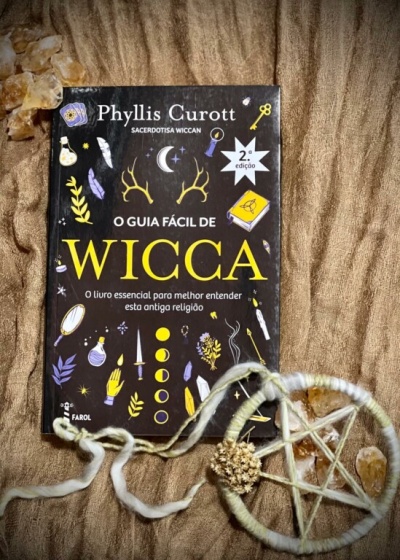 Livro O Guia Fácil de Wicca e colar pentagrama em fundo castanho