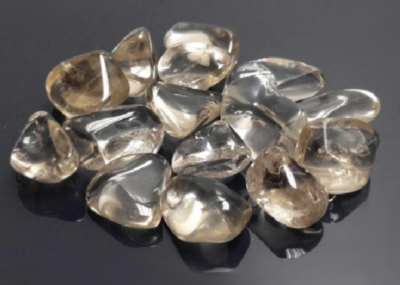 Pedras decorativas transparentes e fumadas polidas sobre fundo escuro