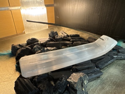 Suporte para incenso em selenite branca com carvão preto e bastão de incenso aceso