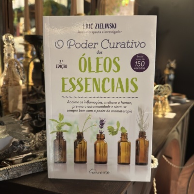 Livro O Poder Curativo dos Óleos Essenciais com imagens de frascos âmbar e plantas.