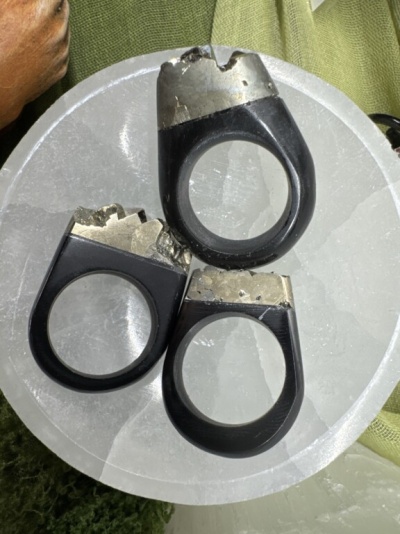 Três anéis pretos com topo prateado sobre prato branco