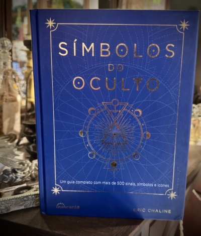 Livro Símbolos do Oculto com capa azul e texto dourado