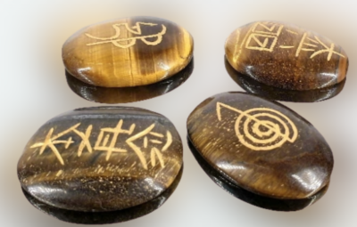Pedras olho de tigre com símbolos dourados gravados