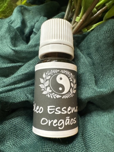 Frasco de óleo essencial de Orégãos sobre tecido verde