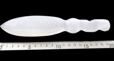 Objeto translúcido branco com gravações, ao lado de régua cm
